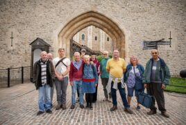 Group photo of participants smiling at the camera outside one of the entrances to the Tower of London.