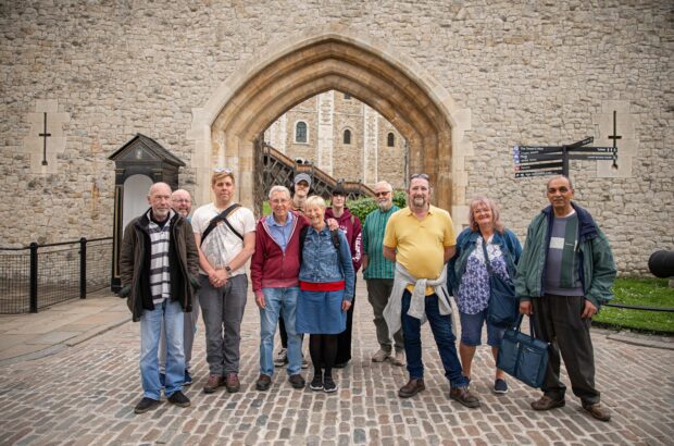 Group photo of participants smiling at the camera outside one of the entrances to the Tower of London.