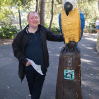 Jack smiling and standing next to a statue based on a parrot.