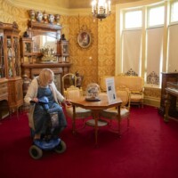 A participant in a mobility scooter admiring a table and chair set with a flower display on.