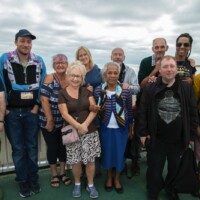 Group photo of participants standing on a pier, smiling at the camera.