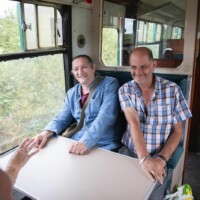 Rob and Kevin sitting together on the train.