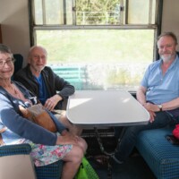 Two participants with Chris, sat at a table on the train.