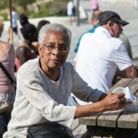 Participant sat at a seaside bench, eating some lunch.