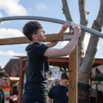 Young person securing the frame of the polytunnel at the allotment.