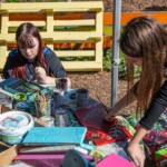 Two young people painting some displays for the allotment.