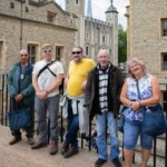 A group photo of some participants, leaning against the railings, with the Tower of London in the background.