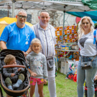 A family enjoying their time at the Cultural Fayre. Three adults and two children, one in a buggy.