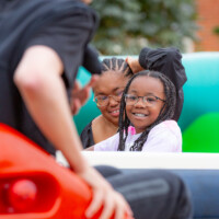 A child smiling as she rides one of the attractions at the fayre.